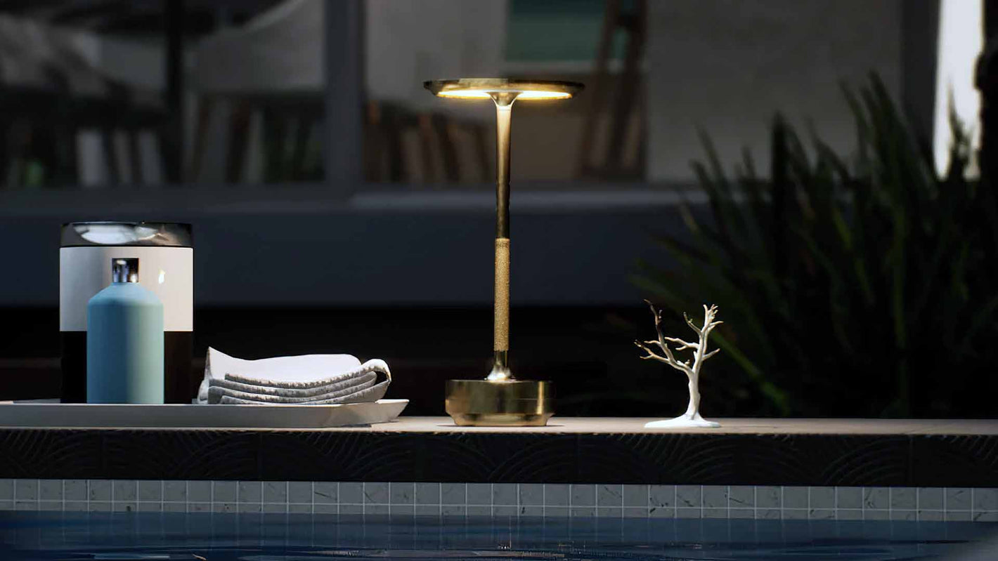 Amberly | Cordless Table Lamp | Aluminum | Gold color of product | Warm light on | Mid-range distance to lamp | Near outdoor pool | Evening