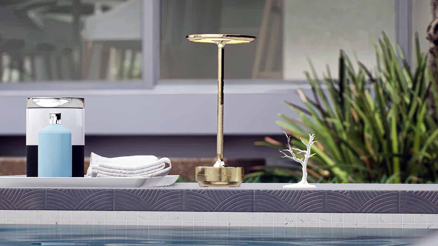 Amberly | Cordless Table Lamp | Aluminum | Gold color of product | Light off | Mid-range distance to lamp | Near outdoor pool | Noon