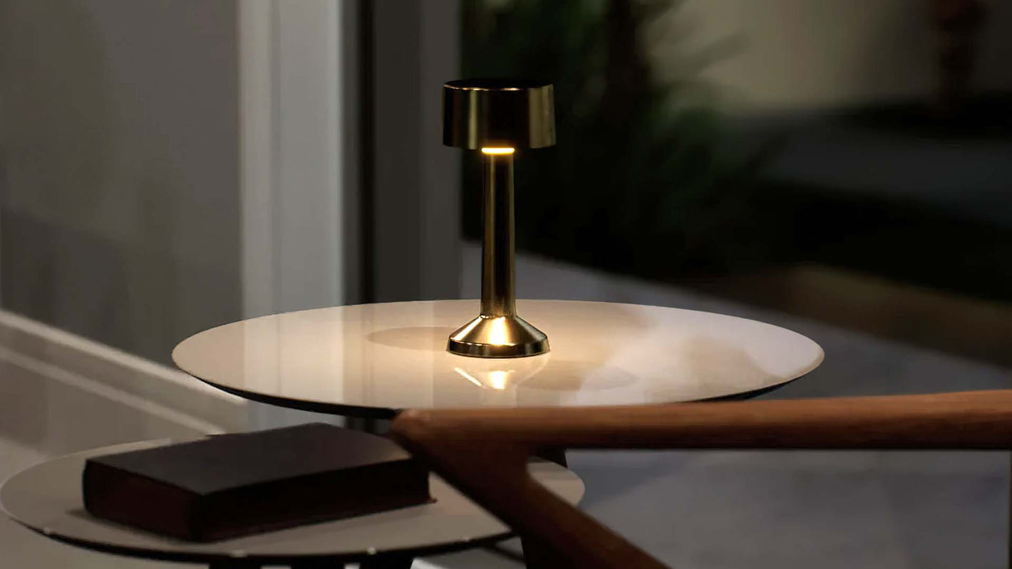 Copri | Cordless Table Lamp | Iron, Acrylic | Gold color of product | Warm light on | Mid-range distance to lamp | At coffee table | Modern interior | Evening | Scene 1