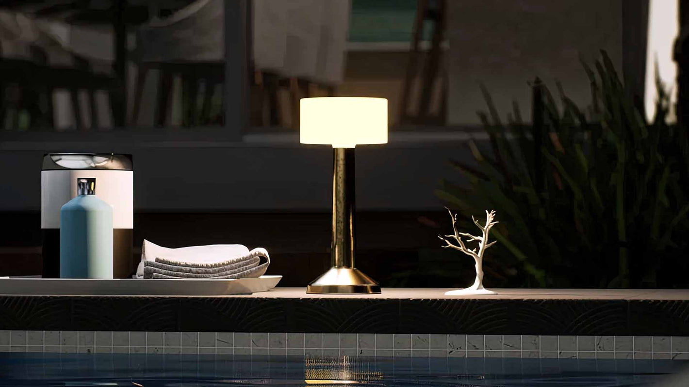Halo | Cordless Table Lamp | Iron, Acrylic | Gold color of product | Warm light on | Mid-range distance to lamp | Near outdoor pool | Evening