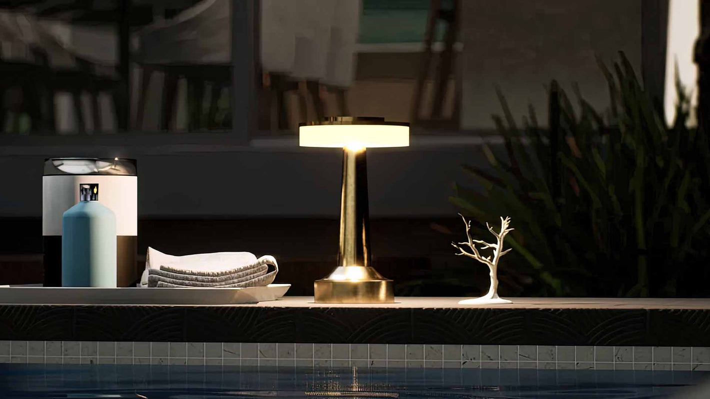 Halo Slim | Cordless Table Lamp | Iron, Acrylic | Gold color of product | Warm light on | Mid-range distance to lamp | Near outdoor pool | Evening