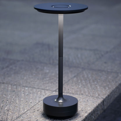 Amberly | Cordless Table Lamp | Aluminum | Black color of product | White light on | Close-up distance to lamp | Near outdoor pool | Evening | Scene 4