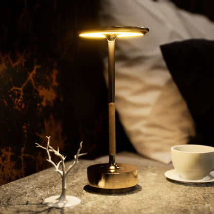 Amberly | Cordless Table Lamp | Aluminum | Gold color of product | Warm light on | Close-up distance to lamp | At bedside table | Modern interior | Evening
