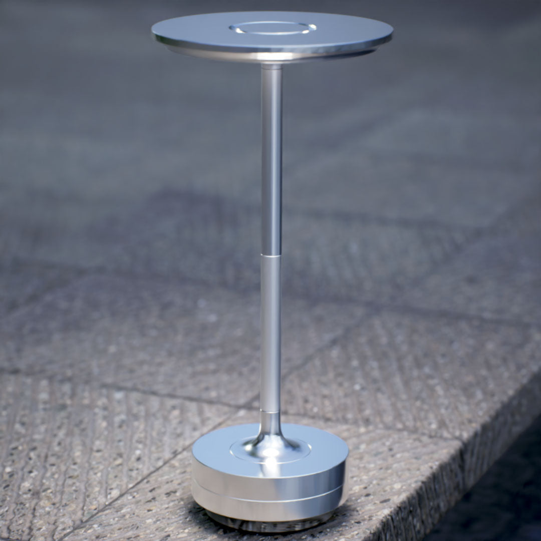 Amberly | Cordless Table Lamp | Aluminum | Silver color of product | White light on | Close-up distance to lamp | Near outdoor pool | Evening | Scene 4